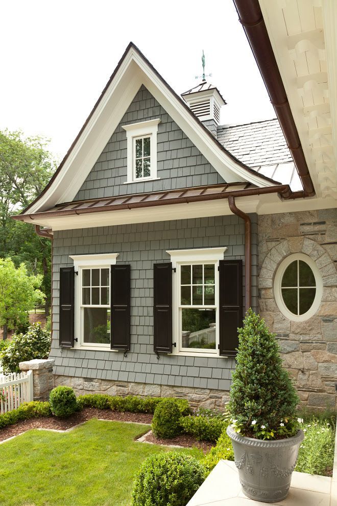 Gray shingled home with copper gutters and black shutters